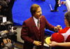 Olympic curling throwback: Commentary about Ron Burgundy commentary Fictional news anchorman Ron Burgundy, played by Will Ferrell, is wearing a burgundy suit jacket and signing autographs for fans at the Olympic curling trials in Winnipeg.