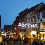 European Christmas markets: Centuries-old tradition keeps on giving A charming historic European town at dusk, lit up all aglow with Christmas lights, shops, and shoppers.
