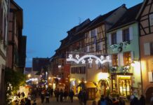 European Christmas markets: Centuries-old tradition keeps on giving A charming historic European town at dusk, lit up all aglow with Christmas lights, shops, and shoppers.