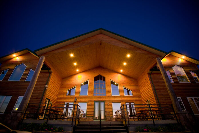 A picture of a massive wooden lodge building, which is part of a wilderness resort designed for corporate retreats.