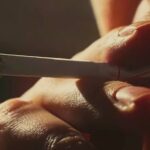How to finally quit smoking for good A close-up shot of someone taking a drag from a cigarette, with a glowing red tip.
