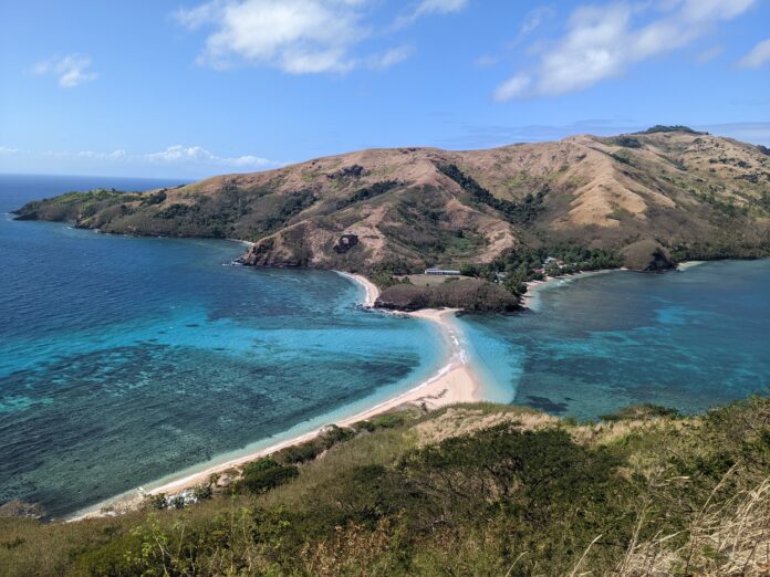 The turquoise waters of the oceans of Fiji flow between islands and natural sandy causeways.