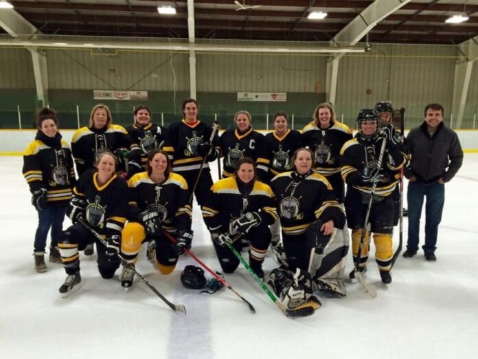 The Goaldiggers women's hockey team pose together on the ice in their hockey gear and team jerseys.