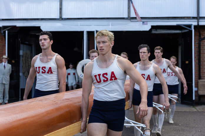 Actor Callum Turner is part of the rowing crew carrying a boat, in the true story of The Boys in the Boat, released by MGM Studios.