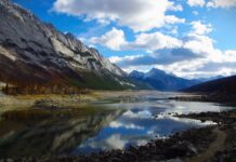 Real life places in the songs of John Denver The picture shows a beautiful blue lake reflecting a mountain, in Jasper, Alberta. Scenes like this come to life in the songs of John Denver.