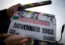 November 1963 movie: The killing of a president A film clapper-board is open and raised to the sky, with the words November 1963 written on them, along with the director's name, Roland Joffe at the bottom.