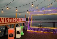 Vancouver at Christmas: Winterless wonderland on the west coast A picture frame made from purple LED lights is on a deck, with the sign 'winterdeck' beside it, and an ocean view behind it.