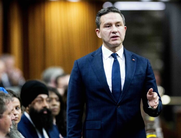 Pierre Poilievre stands up to complain in Canada's House of Commons, as his Conservative colleagues look on.