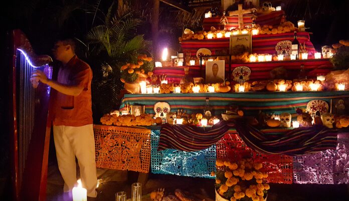 A day of the dead altar is decorated with candles, photos, and mementos.